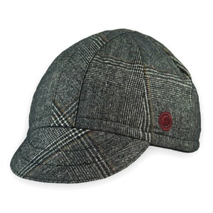 Presta Winter Cap handmade with short brim by Red Dots Cycling. 100% Glen check black/white wool plaid fabric. Black, double-layered, bamboo cotton ribbed ear flap in inside position. Red Dots burgundy logo embroidered on side panel.