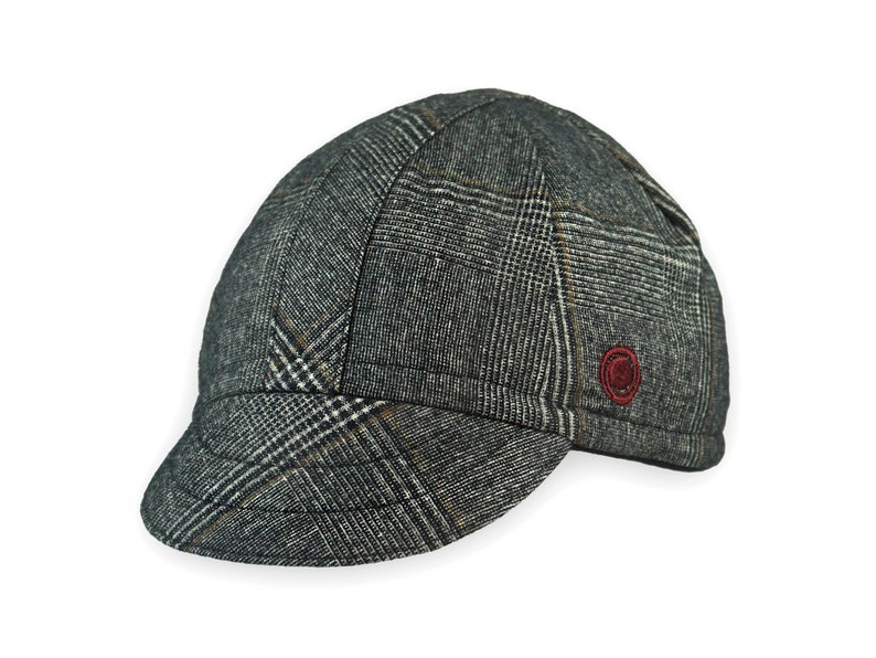 Presta Winter Cap handmade with short brim by Red Dots Cycling. 100% Glen check black/white wool plaid fabric. Black, double-layered, bamboo cotton ribbed ear flap in inside position. Red Dots burgundy logo embroidered on side panel.
