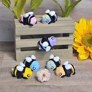 May include: A set of ten colorful bee figurines, each with a different color and pattern. The bees are made of a smooth, glossy material and have a realistic appearance. They are perfect for adding a touch of whimsy to any home decor.