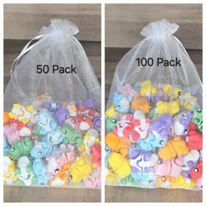 May include: Two white mesh bags filled with colorful small animal figurines. The bag on the left says "50 Pack" and the bag on the right says "100 Pack".