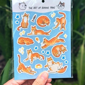 Naklejka na ścianę z rudym kotem | Pomarańczowe, prążkowane koty Garfield bawiące się i śpiące | Słodkie i zwariowane naklejki winylowe