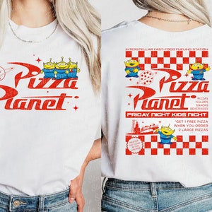Puede incluir: Camiseta blanca con un logotipo rojo y blanco de "Pizza Planet" que presenta tres extraterrestres verdes. La parte posterior de la camiseta tiene un diseño a cuadros rojo y blanco con el mismo logotipo y el texto "Interstellar Fast-Food Fueling Station", "Pizzas, Salads, Snacks, Beverages", "Friday Night Kids Night", y "Get 1 free pizza when you order 2 large pizzas".