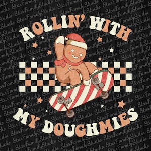 May include: A retro-style graphic featuring a gingerbread man wearing a Santa hat and scarf, skateboarding on a candy cane striped board. The text reads "ROLLIN' WITH MY DOUGHMIES" in a playful font, with star accents.