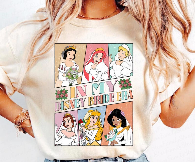 Peut inclure: Un t-shirt blanc avec un graphique color&eacute; repr&eacute;sentant des princesses Disney en robes de mari&eacute;e. Le texte "In My Disney Bride Era" est imprim&eacute; sur le t-shirt.