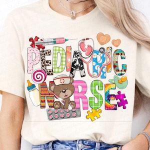 May include: A white t-shirt with a colorful graphic design that says "Pediatric Nurse". The design includes a teddy bear, a stethoscope, a syringe, a pacifier, and other colorful elements.