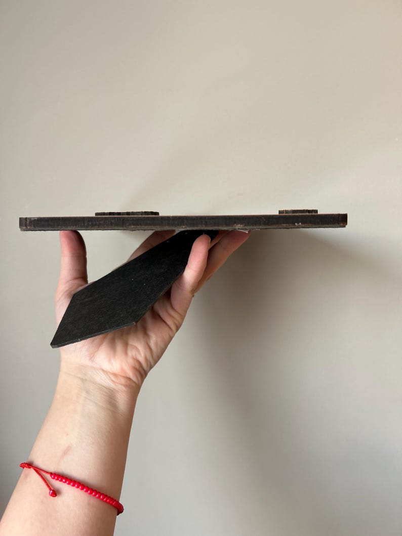 Puede incluir: Un marco de fotos de madera marr&oacute;n con un caballete negro. El marco tiene una superficie texturizada y est&aacute; listo para mostrar una foto o una obra de arte.
