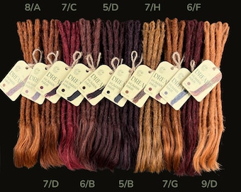 May include: A selection of dreadlocks in shades of brown, red, and auburn, displayed in a row. Each bundle is labelled with a colour code and a tag that reads "DREAM HUMAN HAIR". The background is black.