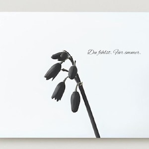 Könnte beinhalten: Ein Schwarz-Weiß-Druck mit einem Zweig dunkler Blütenknospen vor weißem Hintergrund. Der deutsche Text "Du fehlst. Für immer." ist in zarter Schrift oben rechts geschrieben. Das Bild hat eine minimalistische Ästhetik.