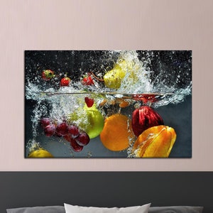 Puede incluir: Una variedad de fruta fresca, incluyendo uvas, peras, manzanas y naranjas, están sumergidas en agua, creando un chapoteo de gotas de agua. La fruta está dispuesta en una composición de bodegón, con el nivel del agua justo por encima de la fruta.