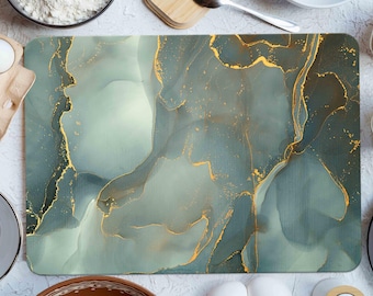 May include: Rectangular cutting board with a teal and gold abstract design. The board has a smooth surface with flowing patterns of teal and gold. The design resembles marble or ink art. The board is surrounded by baking ingredients.