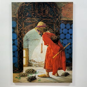 Può includere: Un uomo con una tunica rossa e un turbante si trova in una stanza piastrellata, guardando un gruppo di tartarughe sul pavimento. La stanza ha una parete piastrellata blu e bianca e un portale con intagli intricati. L'uomo tiene un bastone lungo e sottile nella sua mano destra.