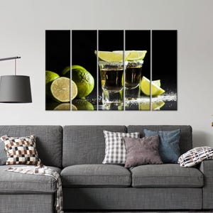 May include: Two shot glasses filled with golden tequila, garnished with lime wedges and rimmed with salt, on a black background with additional lime wedges.