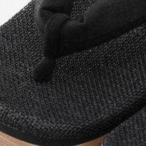 May include: Black woven fabric sandals with a wooden sole. The sandals have a simple design and are made of a durable material.
