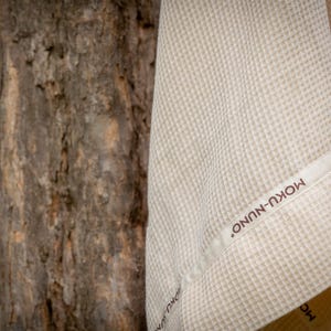 May include: A white waffle weave towel with a brown label that reads "MOKU-NUNO".