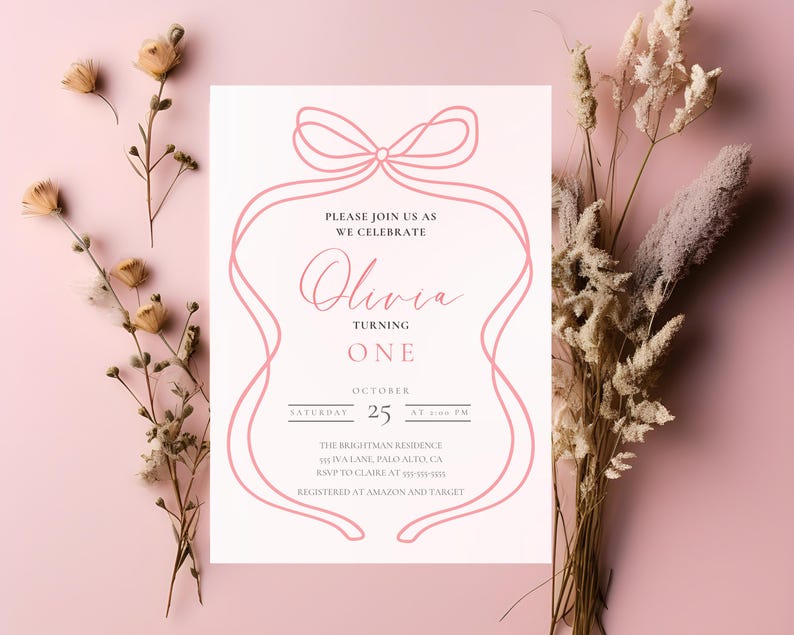 Op de afbeelding: Een roze en witte uitnodiging voor een eerste verjaardag. De uitnodiging heeft een roze lintontwerp rond de tekst "Olivia Turning One". Details zijn de datum, tijd en locatie van het feest.