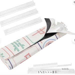 Coordinating Mahjong rack storage bag in a pastel Mahjong tile pattern shown holding clear acrylic Mahjong racks. The image displays four transparent racks, the patterned rack bag with hook-and-loop closure, and a rack loaded with Mahjong tiles.