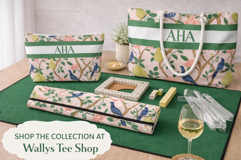 May include: A collection of matching accessories with a floral and bird pattern, including a tote bag, cosmetic bag, and a zippered case. Each item has a white stripe with the initials "AHA". A green mat displays game pieces and a wine glass.