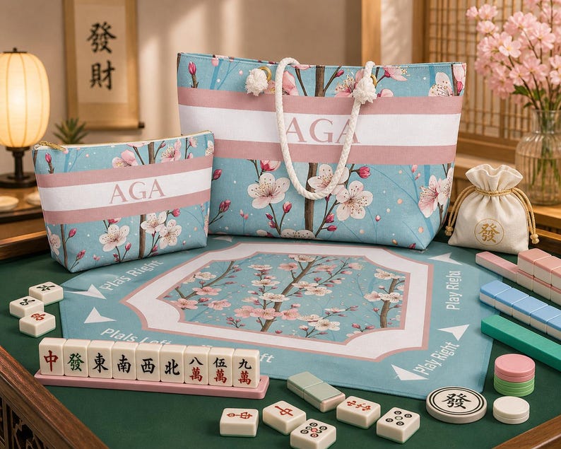 Cherry blossom mahjong bundle with personalized tote bag, matching tile bag, and floral mahjong mat displayed on a mahjong table with tiles and accessories.