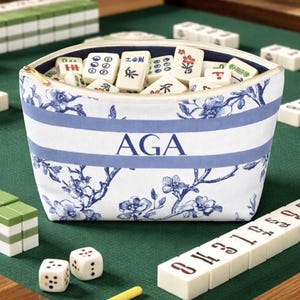 Personalized blue floral toile cosmetic bag with light blue stripe and navy monogram, elegant zipper pouch for makeup or travel essentials.