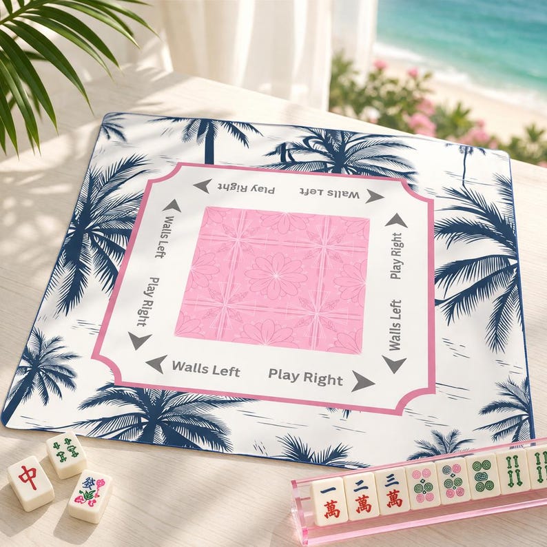 Pink coastal Mahjong mat with palm tree design on a light wood table, styled in a Palm Beach setting with ocean view, Mahjong tiles, and acrylic rack for a preppy beach house aesthetic.