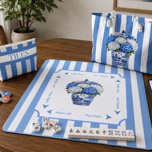 Coastal Mahjong bundle mockup featuring blue striped hydrangea Mahjong mat, matching tile bag, and accessory tote styled together on a wooden game table.