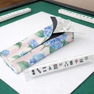 Blue hydrangea and pink striped Mahjong tile bag with clear acrylic tile racks and tiles, displayed on a clean white background with bag partially open.