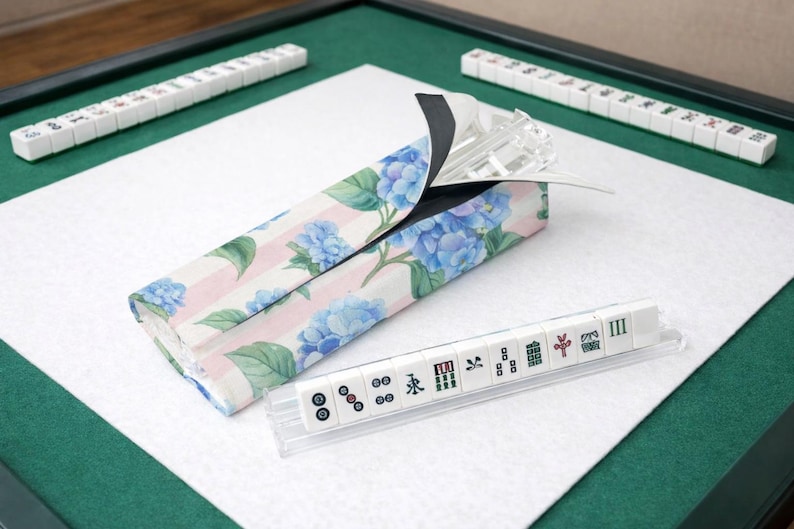 Blue hydrangea and pink striped Mahjong tile bag with clear acrylic tile racks and tiles, displayed on a clean white background with bag partially open.