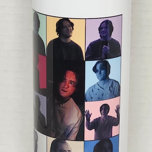 Puede incluir: Vaso blanco con un collage de imágenes de una persona en varias poses, cada una sobre un fondo de color diferente. El texto "BERT REYNOLDS *BOB*" está impreso en el vaso.