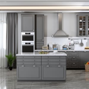 May include: A modern gray kitchen with stainless steel appliances, including a range hood and double ovens. The kitchen features gray cabinets, a white countertop, and a central island with drawers. A dining area with a round table and chairs is visible.