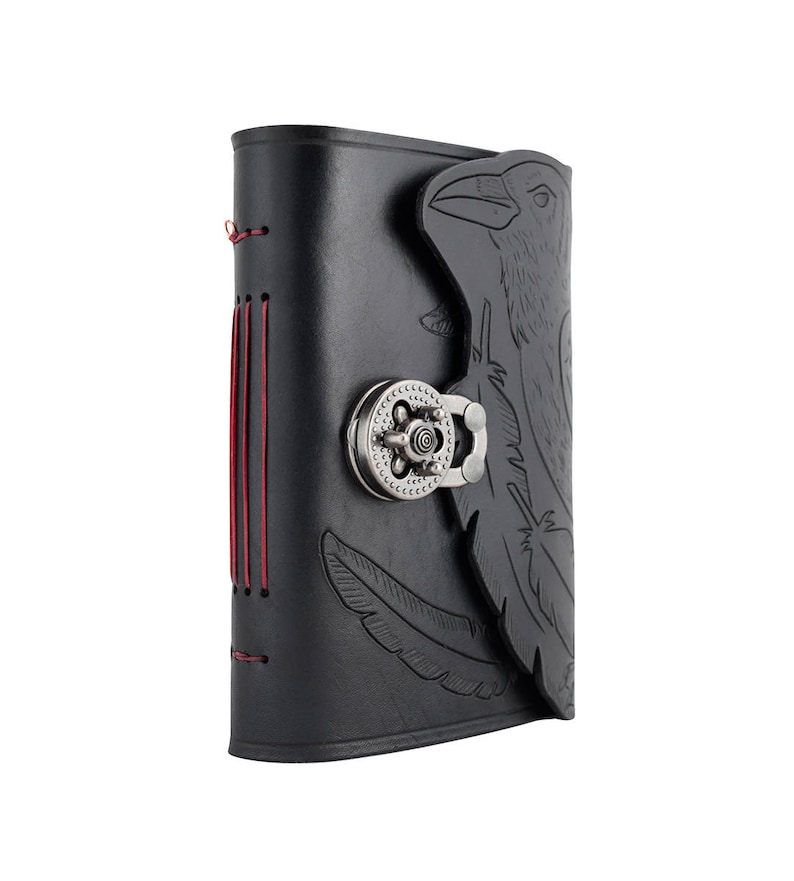 May include: Black leather journal with a raven design embossed on the cover. The journal features a metal clasp closure and red stitching along the spine. A feather is also embossed on the cover.