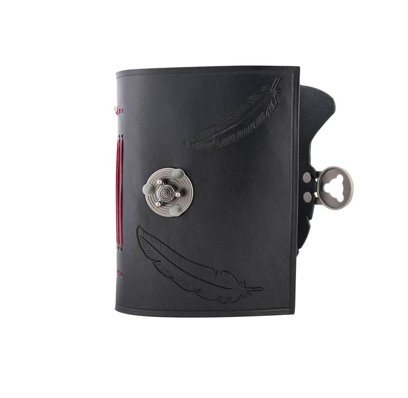 May include: Black leather journal with feather imprints and a silver clasp. The journal has red stitching along the spine and a decorative silver metal closure. The journal is closed.