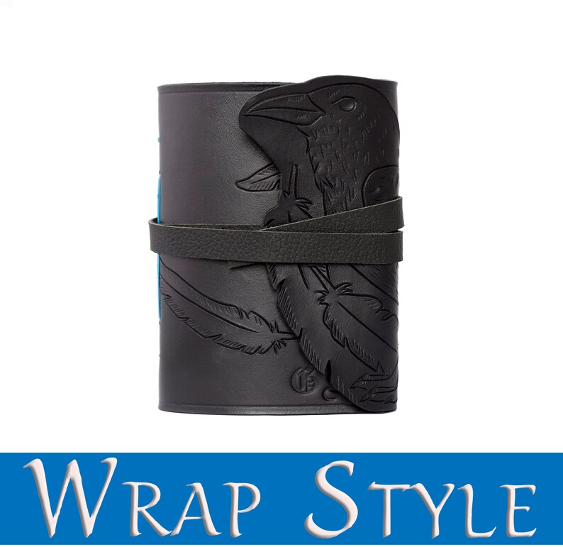 May include: Black leather wrap-style journal with a raven design. The journal features an embossed raven head and feather details. A leather strap wraps around the journal to keep it closed. The text "WRAP STYLE" is at the bottom of the image.