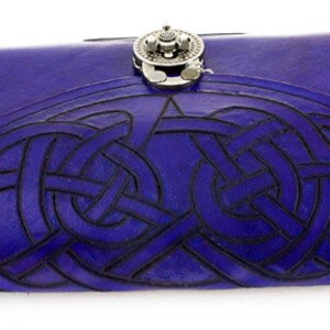 May include: A handcrafted, deep blue leather journal with a Celtic knot design embossed on the cover. The journal features a silver-toned clasp and a detailed, interwoven pattern. The cover is a rich, saturated blue.