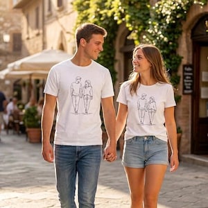 Puede incluir: Dos personas con camisetas blancas a juego con un dibujo lineal de una pareja tomados de la mano. La persona de la izquierda lleva vaqueros azules y la de la derecha, pantalones cortos vaqueros. Caminan por una calle adoquinada.