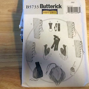 May include: A sewing pattern for a historical costume, featuring a variety of pieces including a pair of gauntlets, a pouch, and a pair of leggings. The pattern is from Butterick, and the pattern number is B5733.