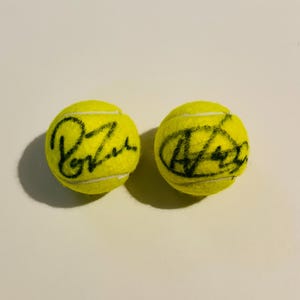 May include: A white ceramic mug with a black handle and the text "But First, Coffee" in a black, bold font. The mug is on a white surface.