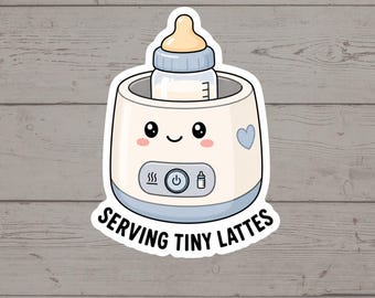Puede incluir: Una pegatina con un calienta biberones de color crema con una cara sonriente, un corazón azul y un biberón dentro. El panel de control muestra iconos de calor, encendido y biberón. El texto debajo dice SERVING TINY LATTES en negro.