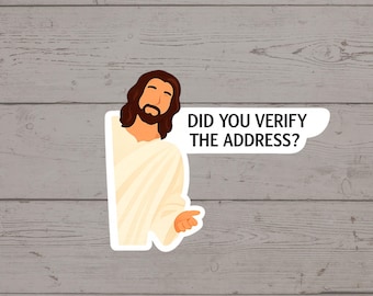 Puede incluir: Una pegatina con una ilustración de dibujos animados de Jesús con una túnica blanca, cabello castaño y barba. Un bocadillo dice: "DID YOU VERIFY THE ADDRESS?" La pegatina está sobre un fondo de madera gris.