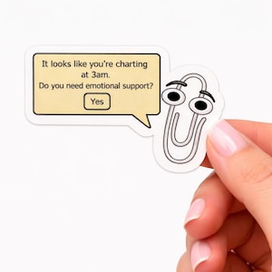 May include: A white sticker featuring a cartoon paperclip with eyes and a speech bubble. The speech bubble contains the text: "It looks like you're charting at 3am. Do you need emotional support? Yes."
