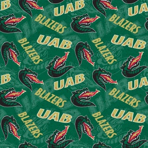 Puede incluir: Un patrón de tela verde y dorado con un diseño repetido de un dragón verde con llamas rojas, las palabras "UAB" y "BLAZERS".