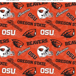 May include: Orange fabric with a repeating pattern of a black and white beaver mascot, a football helmet, and the words "Oregon State" and "Beavers". The fabric is 100% cotton and measures 43/44 inches.