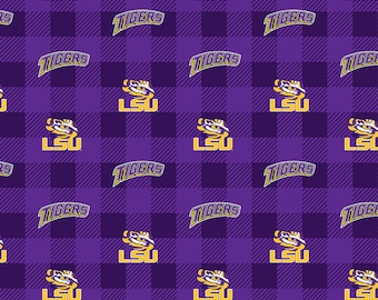 May include: Purple and gold checkered fabric with the words "LSU Tigers" repeated throughout the pattern.