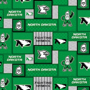 Puede incluir: Tela verde y gris con un patrón repetido del logotipo de los North Dakota Fighting Hawks. El logotipo presenta una cabeza de águila verde, las letras ND y las palabras "North Dakota Fighting Hawks".