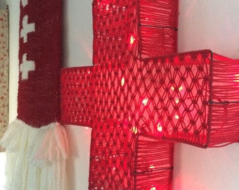 Large bright red cross in macramé