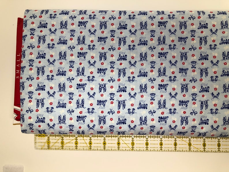 May include: Blue fabric with a repeating pattern of red flowers, white stars, and blue and white train designs.