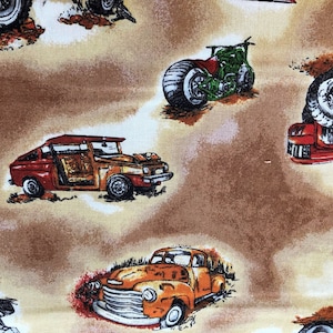 Puede incluir: Una tela marr&oacute;n y beige con un patr&oacute;n repetido de coches y motocicletas antiguas. Los coches son rojos, naranjas y verdes. Las motocicletas son verdes y negras.