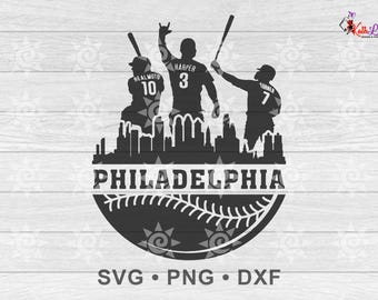 May include: Black and white silhouette of three baseball players with their jersey numbers visible: 10, 3, and 7. The players are standing in front of a cityscape with the word "PHILADELPHIA" above a baseball. The text "SVG. PNG. DXF" is below the baseball.