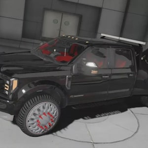 May include: A black tow truck with red interior and custom wheels. The truck has a tow bed and a light bar on top. The wheels have a silver finish with red accents. The truck is parked in a modern, industrial-style setting.