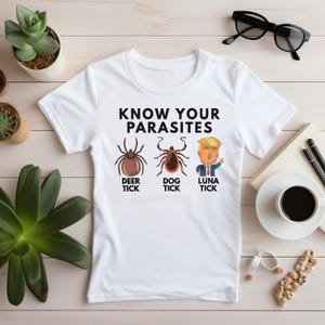 May include: White t-shirt with the text "KNOW YOUR PARASITES" and illustrations of three ticks labeled "DEER TICK", "DOG TICK", and "LUNA TICK".