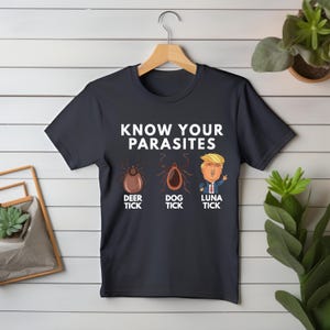 May include: A dark blue t-shirt with the text "KNOW YOUR PARASITES" and three cartoon images of ticks labeled "DEER TICK", "DOG TICK", and "LUNA TICK".